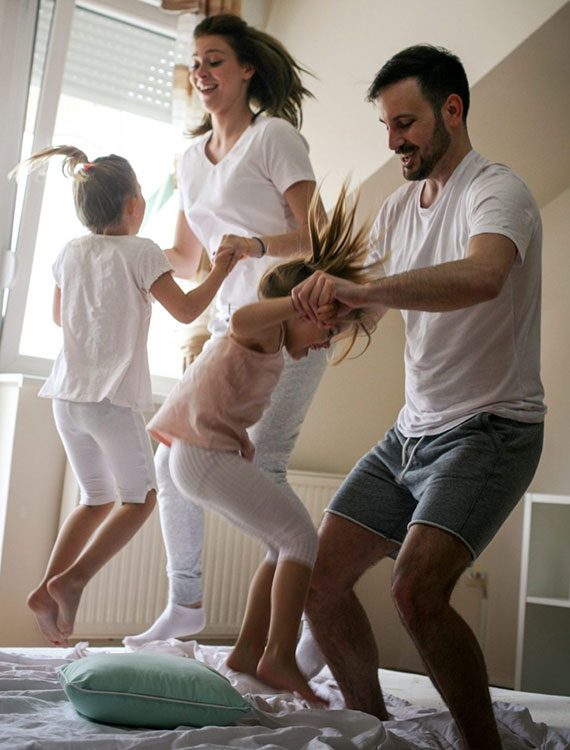 Happy family jumps on be together